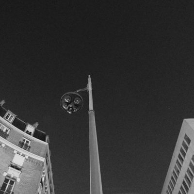 Street lamp against the night sky between two buildings